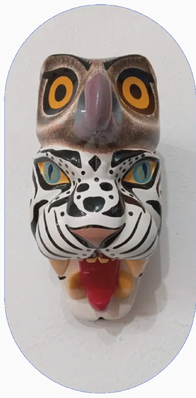 Máscara con cabeza de búho café sobre un tigre blanco de rayas negras con la lengua roja de fuera