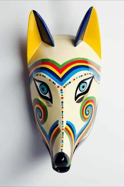 Máscara de coyota de rostro blanco con orejas amarillas, franjas y espirales de arcoíris y nariz negra