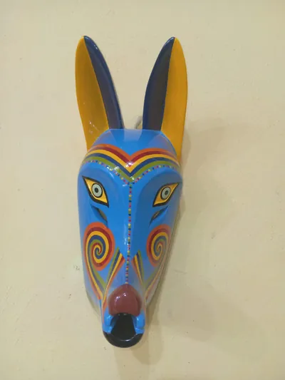 Máscara de coyote azul con orejas amarillas y espirales de colores del arcoíris en las mejillas