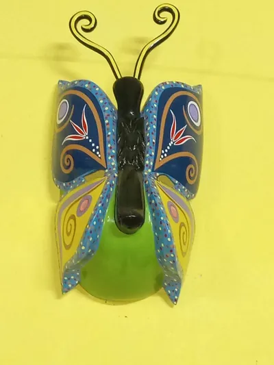 Máscara de mariposa con alas azul marino y amarillas decoradas con espirales y antenas enroscadas
