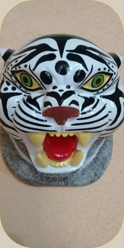 Máscara de tigre blanco con rayas negras, ojos verdes y fauces abiertas con colmillos