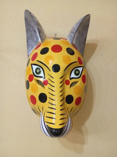 Máscara de ocelote amarillo con lunares rojos, anaranjados y negros y orejas grises