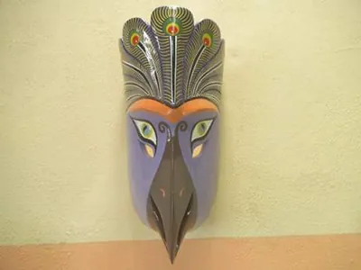 Máscara de ave morada con penacho de plumas de pavo real y pico gris oscuro