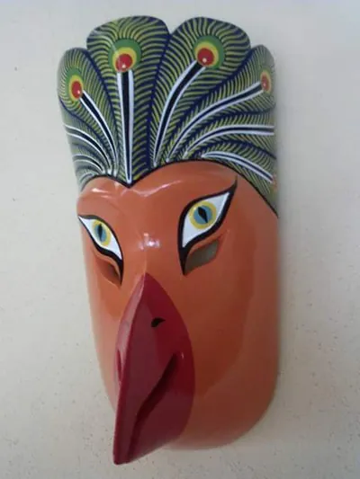 Máscara de ave anaranjada con penacho verde de plumas de pavo real y pico rojo
