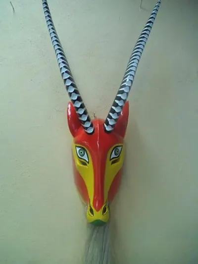 Máscara de chivo roja y amarilla con cuernos largos rayados en blanco y negro y barba blanca