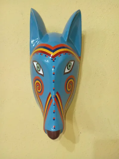 Máscara de coyote azul con bandas de colores en la frente y espirales en las mejillas
