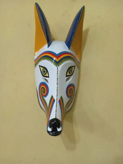 Máscara de coyote blanca con bandas y espirales de arcoíris y orejas amarillas y azules