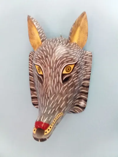 Máscara de lobo gris con trazos blancos, orejas doradas, ojos amarillos y nariz roja