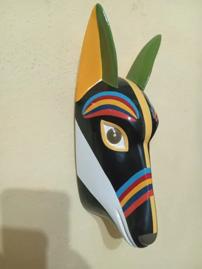 Máscara de perro xoloitzcuintle negro con orejas verdes y amarillas, cejas y banda de arcoíris en el hocico