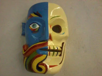 Máscara de rostro partido, mitad azul con barba de arcoíris y mitad calavera color hueso