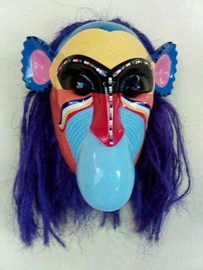 Máscara de mandril con nariz roja, mejillas azules acanaladas y cabellera de fibra morada