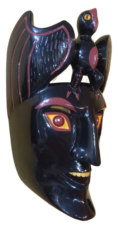 Máscara de rostro negro con sonrisa amarilla, alas negras extendidas y un ave negra posada sobre la frente