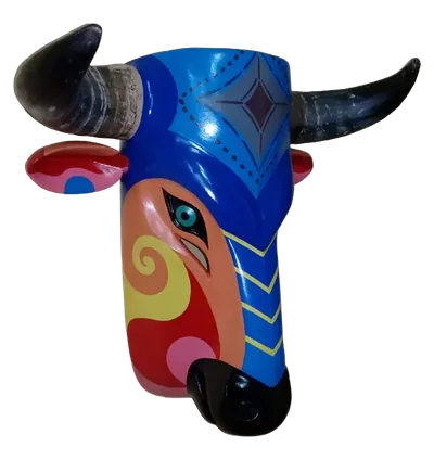 Máscara de toro azul con cuernos oscuros, hocico negro y un costado anaranjado con espiral amarilla